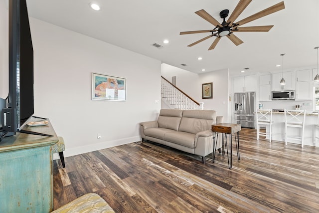 living area featuring ceiling fan, visible vents, stairway, dark wood-style floors, and recessed lighting