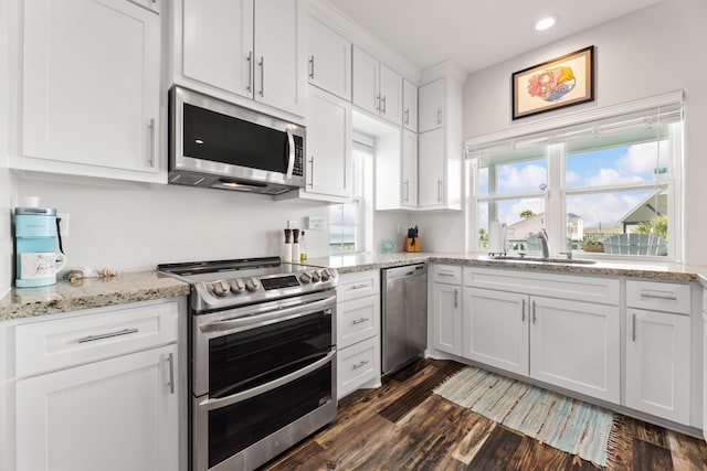 kitchen featuring white cabinets, appliances with stainless steel finishes, a sink, and dark wood finished floors