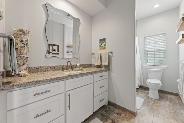 bathroom with vanity, baseboards, and toilet