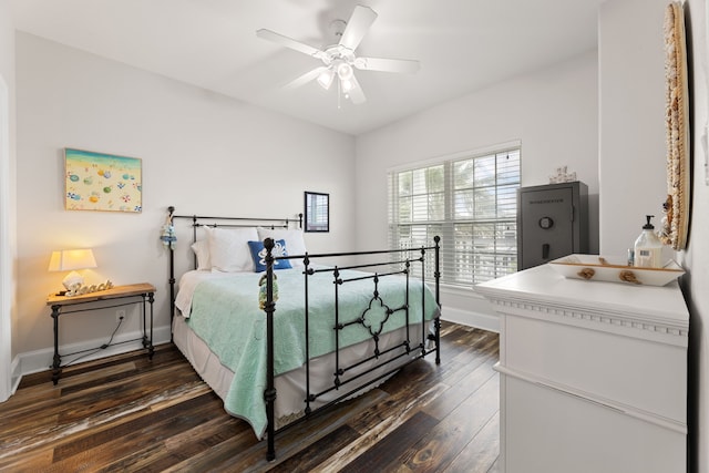 bedroom with baseboards, a ceiling fan, and dark wood-style floors