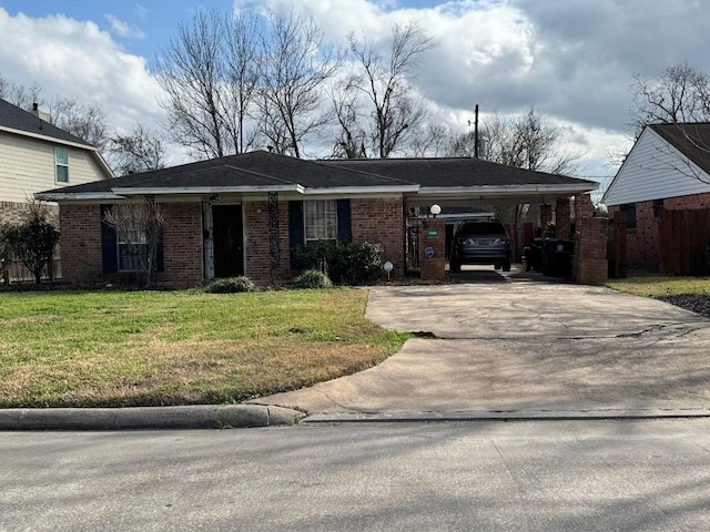 view of front of property featuring an attached carport, driveway, a front lawn, and brick siding