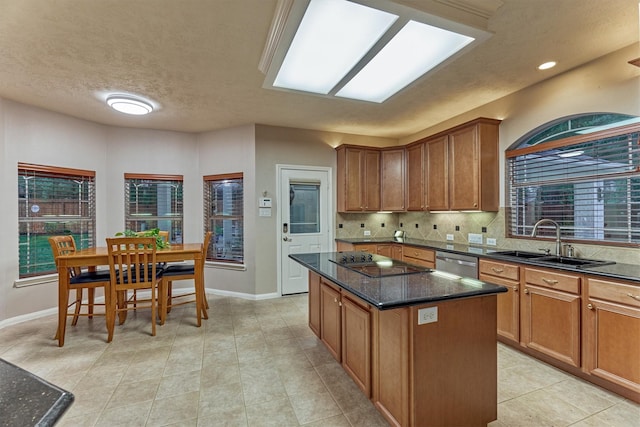 kitchen featuring a sink, black electric stovetop, stainless steel dishwasher, baseboards, and a textured ceiling