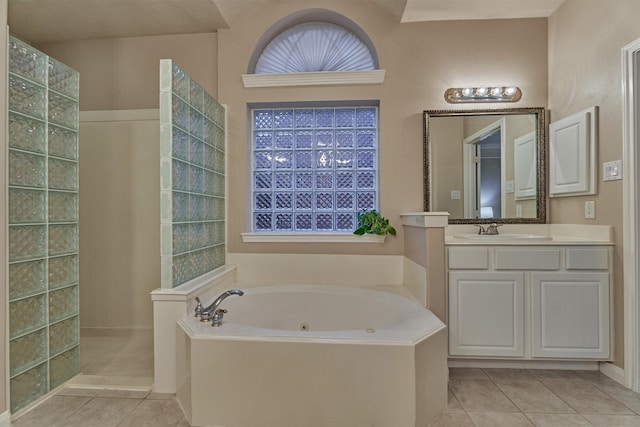 full bath with tile patterned flooring, a jetted tub, a walk in shower, and vanity