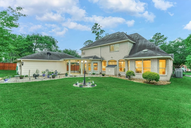 back of house featuring central AC unit and roof with shingles
