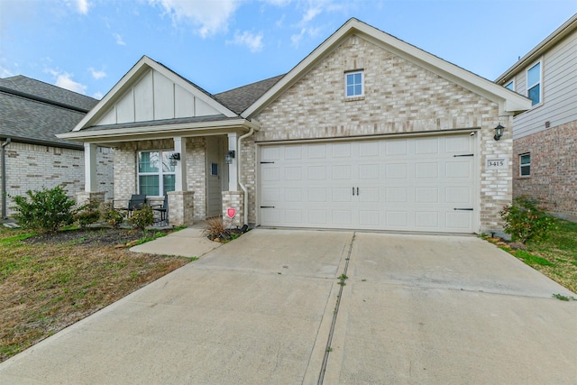 view of front of property with board and batten siding, covered porch, driveway, brick siding, and an attached garage