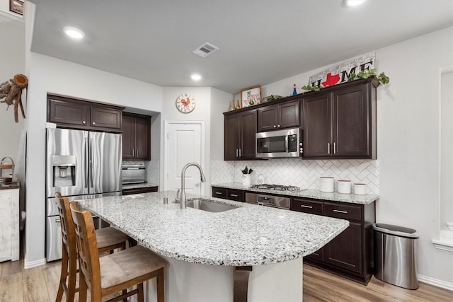 15502 Bosque Valley Ct, Cypress, TX 77433 - kitchen with a sink, stainless steel appliances, light wood-style flooring, and visible vents