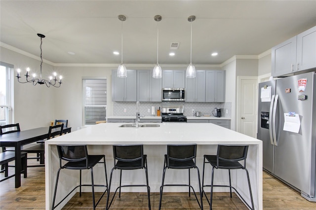 14514 Sanour Dr, Houston, TX 77084 - kitchen featuring backsplash, wood finished floors, a sink, a chandelier, and stainless steel appliances