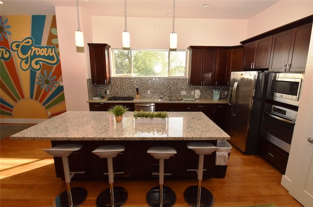 3804 Lovejoy St, Houston, TX 77003 - kitchen featuring a breakfast bar, a sink, stainless steel appliances, backsplash, and a kitchen island