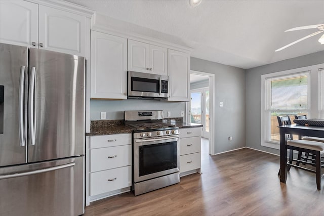 1094 Redfish St, Hitchcock, TX 77563 - kitchen with ceiling fan, appliances with stainless steel finishes, wood finished floors, baseboards, and white cabinetry