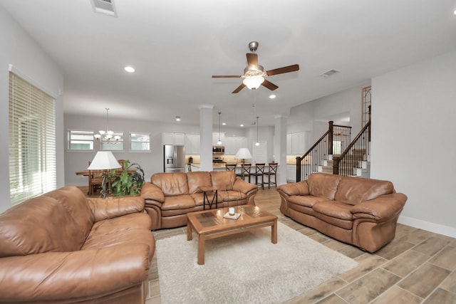 living room with ceiling fan, a chandelier, light wood-type flooring, recessed lighting, and stairway