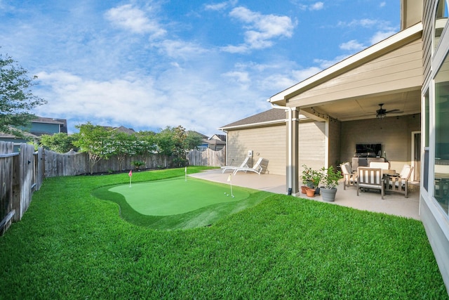 view of yard featuring an area to practice putting, a patio area, ceiling fan, and an outdoor living space