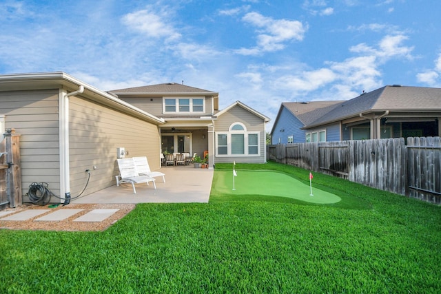 rear view of house featuring a putting area, a patio, and ceiling fan