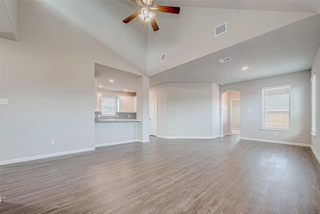 10103 Gold Finch Run, Magnolia, TX 77354 - unfurnished living room featuring a ceiling fan, arched walkways, visible vents, and wood finished floors