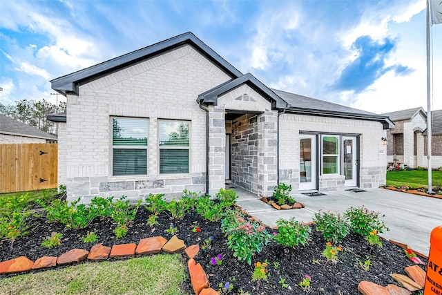 26234 Cooperstown Way, Splendora, TX 77372 - view of front of property featuring fence, a patio, brick siding, and stone siding
