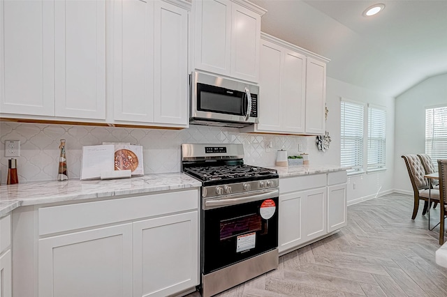 26234 Cooperstown Way, Splendora, TX 77372 - kitchen featuring lofted ceiling, baseboards, recessed lighting, white cabinets, and appliances with stainless steel finishes