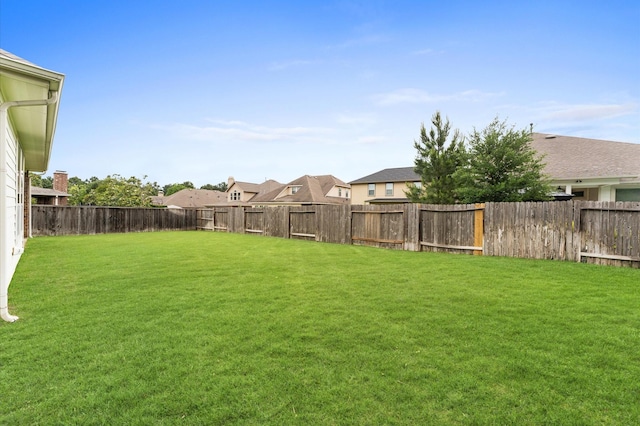 view of yard featuring a fenced backyard and a residential view