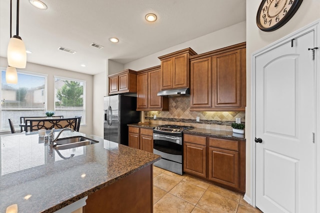 kitchen with visible vents, under cabinet range hood, a sink, backsplash, and stainless steel appliances