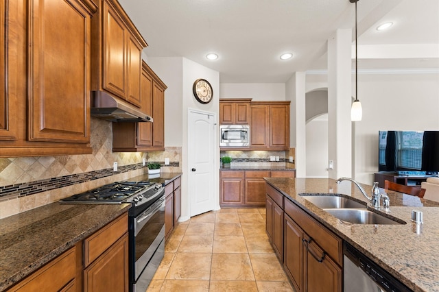 kitchen featuring a sink, appliances with stainless steel finishes, under cabinet range hood, and brown cabinets