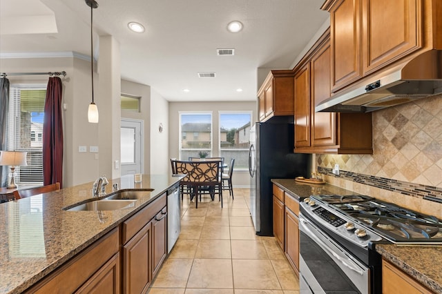 kitchen with visible vents, under cabinet range hood, brown cabinets, a sink, and appliances with stainless steel finishes