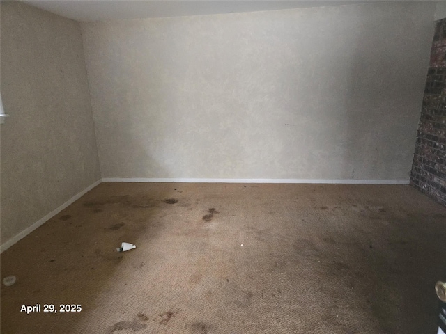 unfurnished room with carpet flooring and baseboards