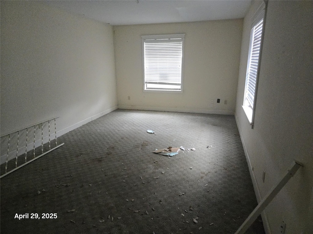 unfurnished room featuring a healthy amount of sunlight, baseboards, and carpet flooring