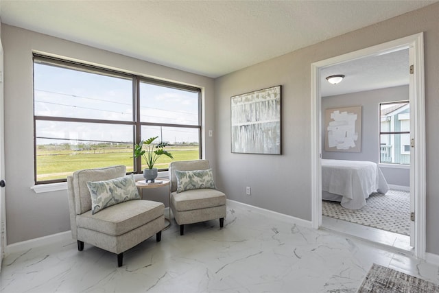 12928 John Reynolds Rd, Galveston, TX 77554 - living area with a textured ceiling, baseboards, and marble finish floor