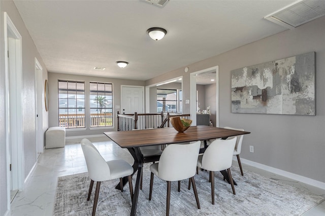 12928 John Reynolds Rd, Galveston, TX 77554 - dining space featuring marble finish floor, baseboards, and visible vents