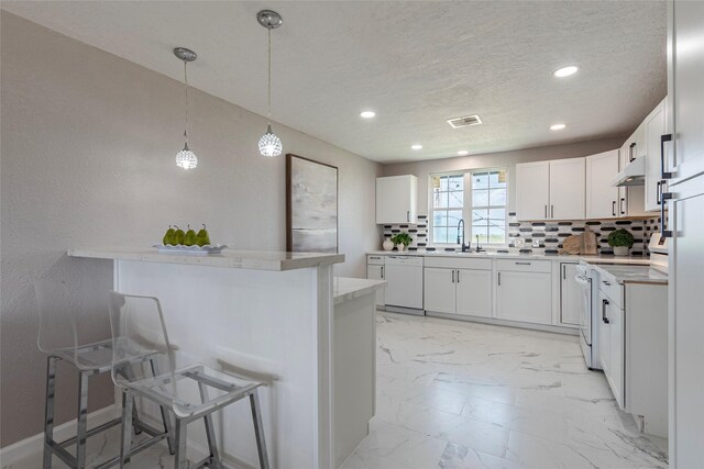 12928 John Reynolds Rd, Galveston, TX 77554 - kitchen with backsplash, marble finish floor, a kitchen bar, and white appliances