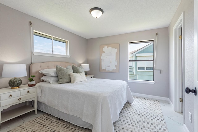12928 John Reynolds Rd, Galveston, TX 77554 - bedroom featuring a textured ceiling, baseboards, and light tile patterned floors