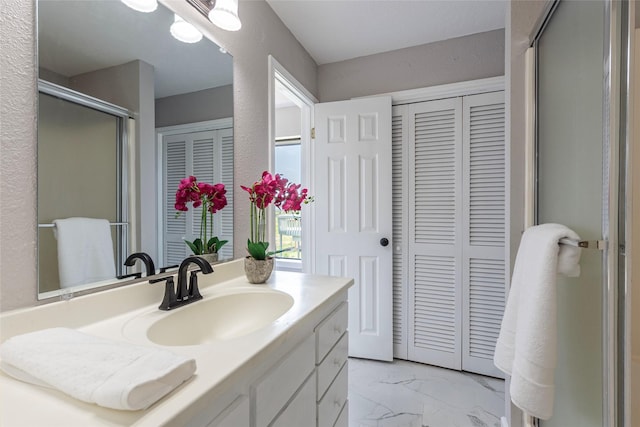 12928 John Reynolds Rd, Galveston, TX 77554 - bathroom featuring a closet, a stall shower, marble finish floor, and vanity