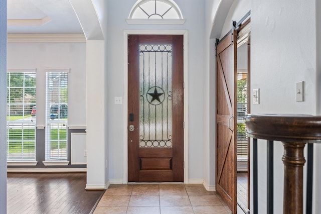 3011 Rustic Gardens Dr, Spring, TX 77386 - entrance foyer with a barn door, arched walkways, healthy amount of natural light, ornamental molding, and baseboards