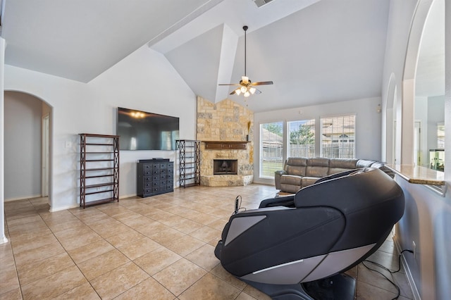 3011 Rustic Gardens Dr, Spring, TX 77386 - living area featuring arched walkways, ceiling fan, a stone fireplace, high vaulted ceiling, and light tile patterned floors