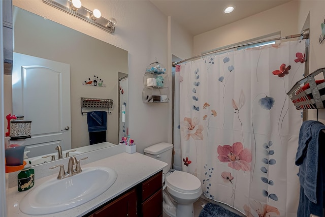 bathroom featuring vanity, toilet, and curtained shower