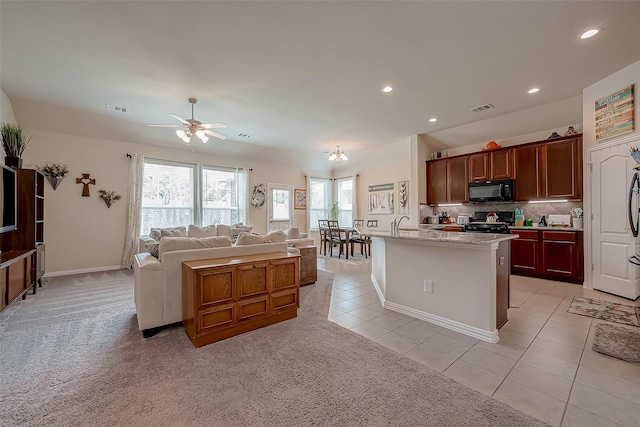 kitchen with visible vents, black microwave, stove, open floor plan, and recessed lighting