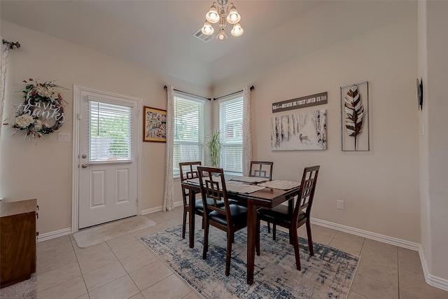 dining space with an inviting chandelier, visible vents, light tile patterned flooring, baseboards, and vaulted ceiling