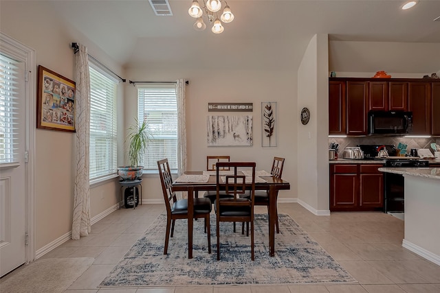 dining area featuring an inviting chandelier, lofted ceiling, light tile patterned flooring, and visible vents