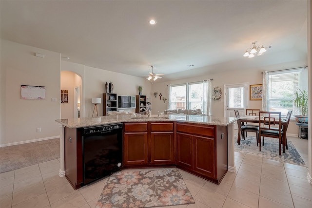 kitchen featuring arched walkways, a sink, open floor plan, black dishwasher, and light tile patterned flooring