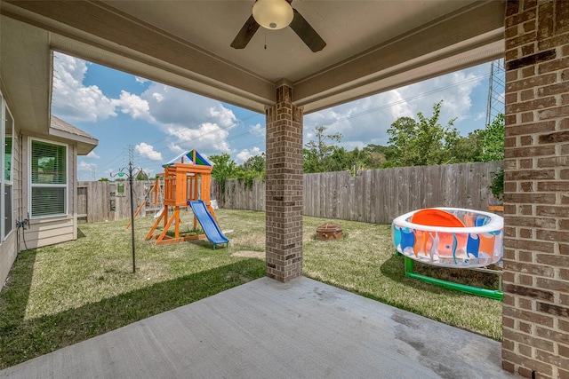 view of patio with a fenced backyard, ceiling fan, and a playground