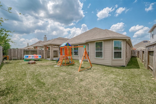 view of jungle gym featuring a lawn and a fenced backyard