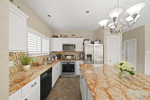 kitchen featuring appliances with stainless steel finishes, an inviting chandelier, a sink, white cabinetry, and backsplash