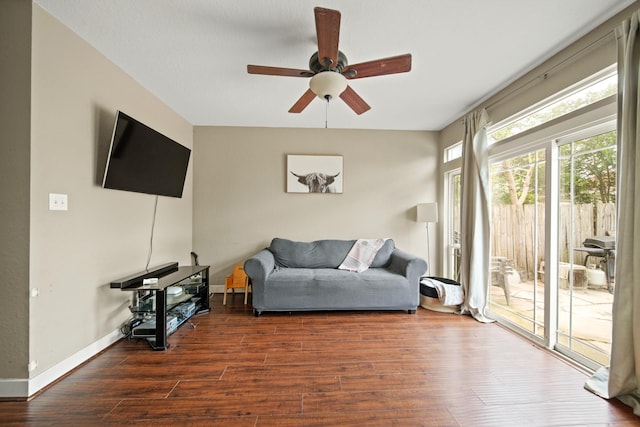 living room featuring baseboards, a ceiling fan, and wood finished floors