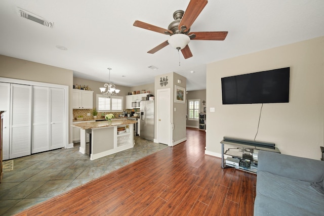 kitchen featuring visible vents, plenty of natural light, stainless steel fridge with ice dispenser, and ceiling fan with notable chandelier