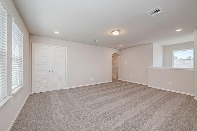 27083 Badger Way, Magnolia, TX 77354 - spare room featuring visible vents, arched walkways, baseboards, and carpet floors