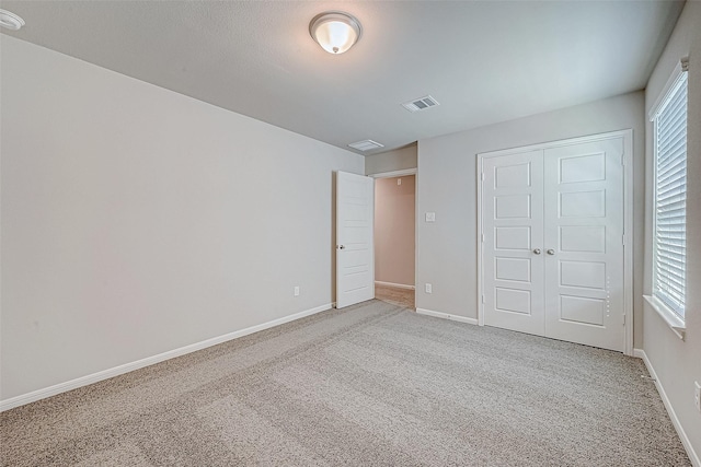 27083 Badger Way, Magnolia, TX 77354 - unfurnished bedroom featuring multiple windows, carpet flooring, and visible vents