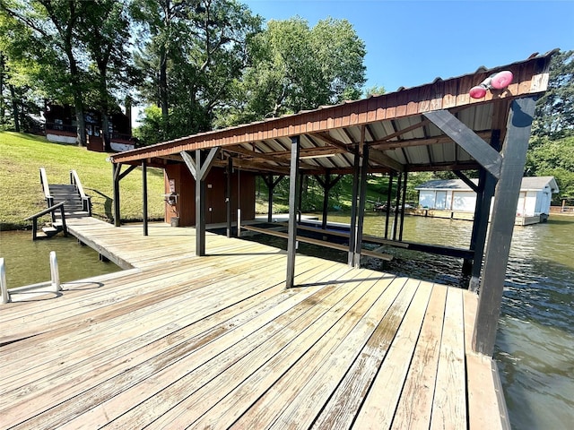 dock area with a yard, a water view, and boat lift