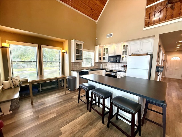 kitchen with visible vents, crown molding, high vaulted ceiling, a sink, and stainless steel appliances