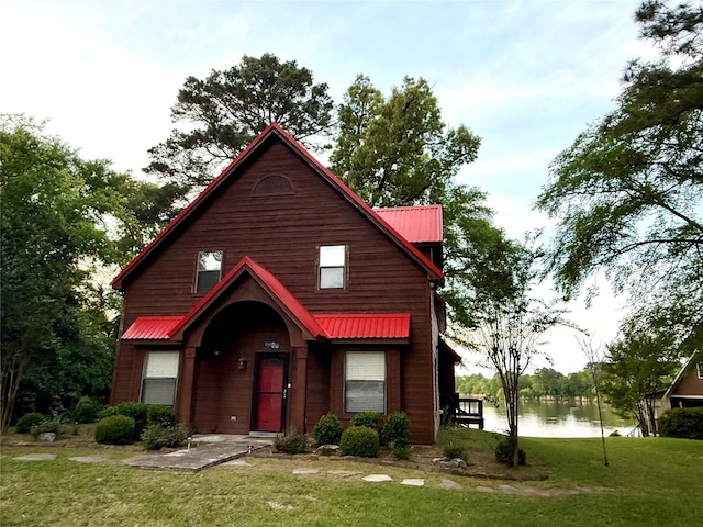 view of front of property featuring a water view, a front yard, and metal roof
