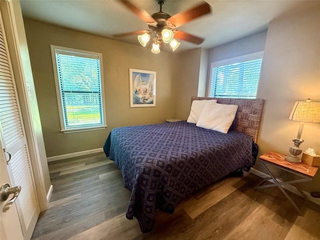 bedroom with baseboards, ceiling fan, and wood finished floors