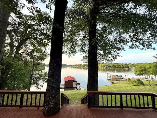 deck featuring a lawn, a water view, and a boat dock