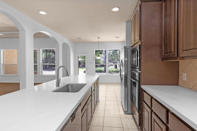 kitchen with oven, a sink, light countertops, recessed lighting, and light tile patterned floors